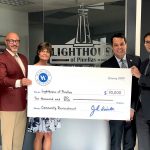 Representatives from Hancock Whitney holding large donation check with Lighthouse Pinellas CEO, Kim Church