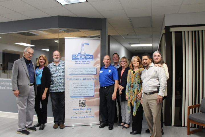 2025 Impact Report Lighhouse supporters standing next to a banner at Dining in the Dark